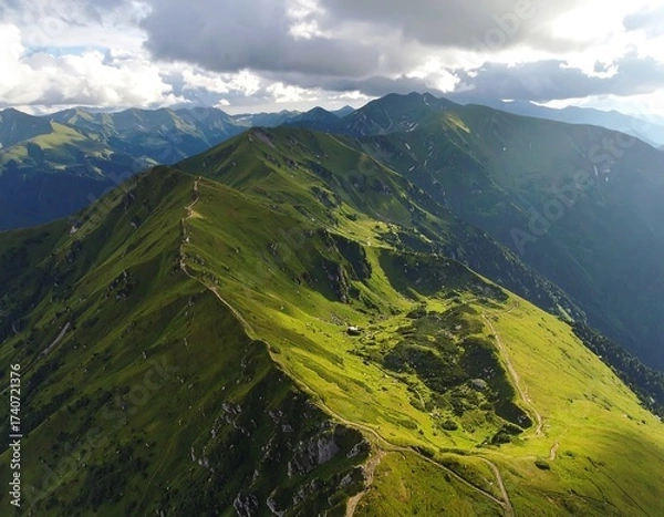 Fototapeta Aerial view of a sunlit green mountain ridge
