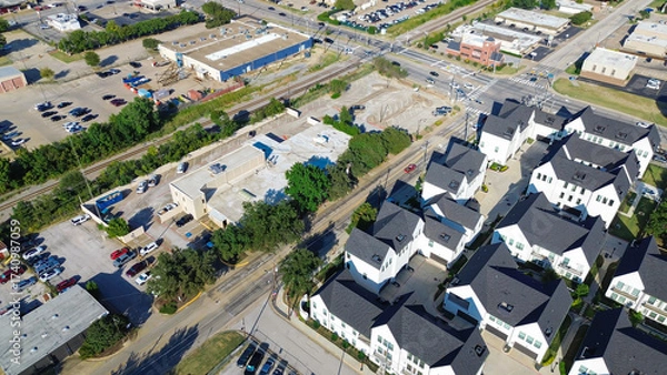 Fototapeta Downtown Arlington, Texas showing gated townhomes, flat roof commercial buildings, railroad tracks. Busy Cooper and Main Street frame a transit-rich corridor near college campus and retail zones