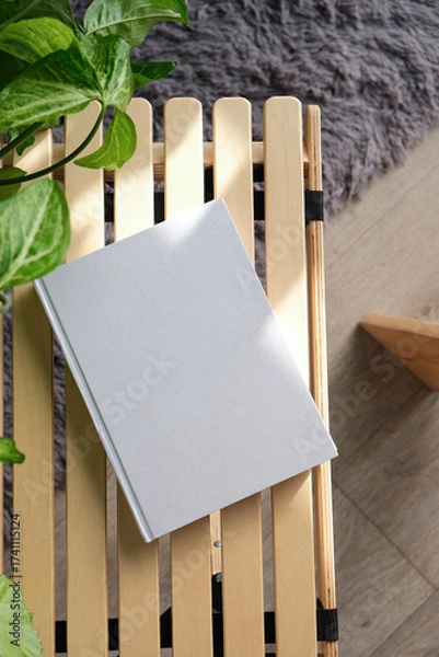 Fototapeta blank book mockup on decorative table with many green plants