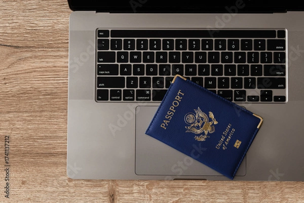 Fototapeta United States passport on laptop keyboard, symbolizing modern travel, digital identity verification, and international documentation