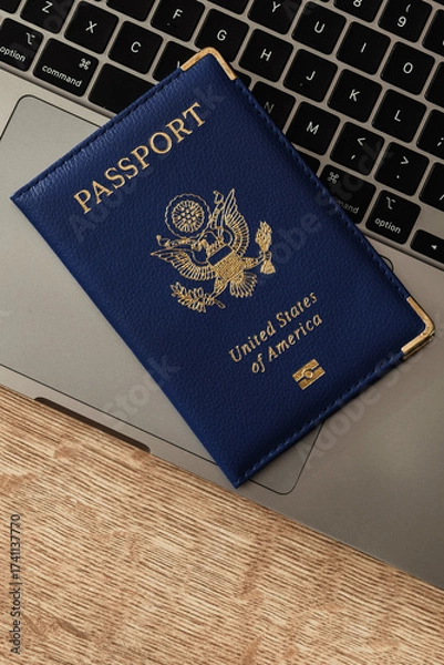 Fototapeta United States passport on laptop keyboard, symbolizing modern travel, digital identity verification, and international documentation