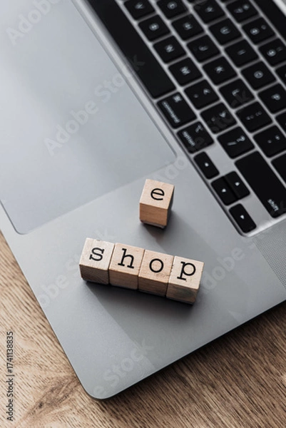 Fototapeta Wooden blocks spelling e shop on laptop, concept of online store and modern e-commerce platform