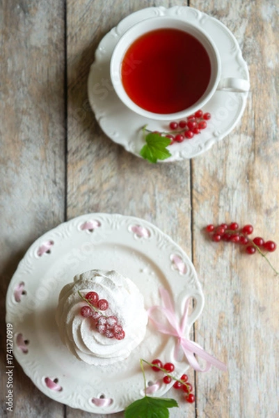 Fototapeta Red currant cake and a cup of aromatic tea in a porcelain cup on the table.