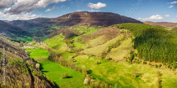 Fototapeta Lush green hills and valleys create a picturesque landscape in the countryside, offering a serene and tranquil view