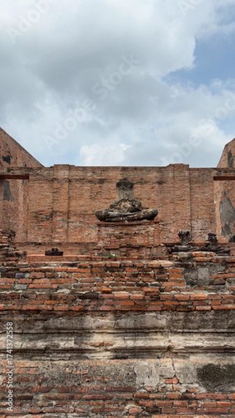 Fototapeta Wat Chaiwatthanaram in Ayutthaya, Thailand. Scenic ruins of the Buddhist temple in the ancient city. Parts of Buddha statues.
