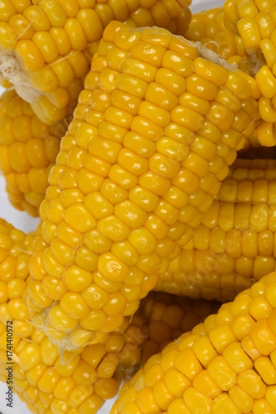Fototapeta A vibrant close-up shows a pile of freshly cooked corn cobs, highlighting the shiny, bright yellow kernels