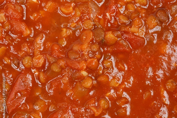 Fototapeta A close-up of a rich, thick vegan lentil and tomato sauce, highlighting the texture of the lentils and chopped vegetables