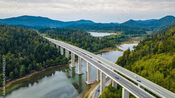Obraz Panoramic aerial view of the toll highway (Autocesta A6) bridge near Fužine (Fuzine) and Lake Bajer in Gorski Kotar, Croatia, surrounded by green mountains and forests