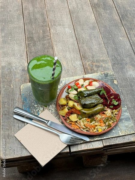 Fototapeta Healthy Vegan Lunch Plate with Green Smoothie on Rustic Wooden Table. Copyspace