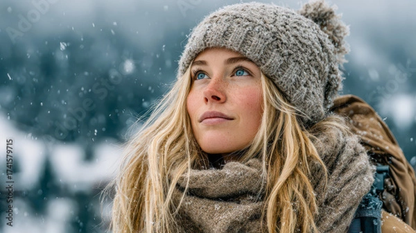 Fototapeta Joyful wanderer gazes at snow-covered mountains while enjoying a winter adventure in a serene landscape