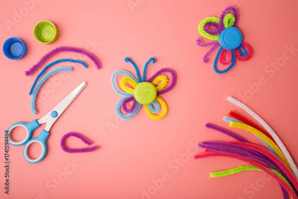 Fototapeta Butterflies made of colorful pipe cleaners and plastic bottle caps, DIY craft for kids, recycling project, creative activity, handmade idea for school, workshop, education, eco learning,