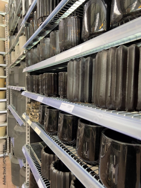 Fototapeta Rows of stylish ceramic and stone planters fill the shelves in a home goods store, featuring diverse shapes and finishes perfect for houseplants and decoration