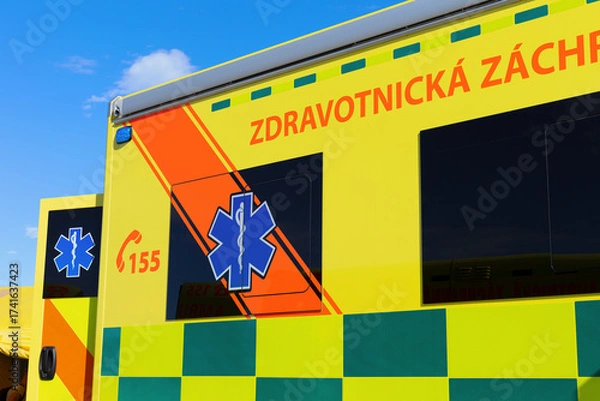 Fototapeta Ambulance emergency vehicle in the Czech Republic and Czechia. Text translated from Czech: Medical rescue. Detail of yellow car with bright reflective colors and symbol Rod of Asclepius.