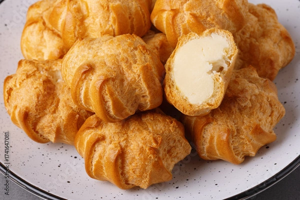 Fototapeta Cakes profiteroles arranged on a plate ready for enjoyment during a cozy afternoon