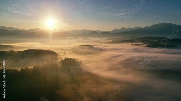 Obraz Sunrise over mountain peaks, mist rolling through valleys, cinematic landscape.
