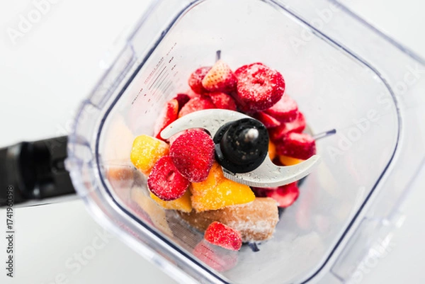 Fototapeta Frozen Fruit Smoothie Prep in Blender Top View with strawberries mango banana