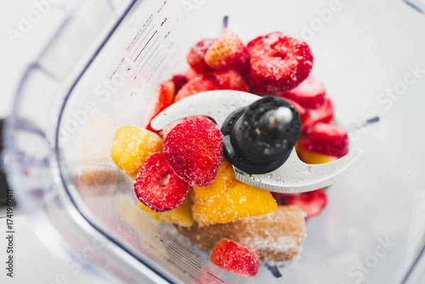 Fototapeta Frozen Fruit Smoothie Prep in Blender Top View with strawberries mango banana