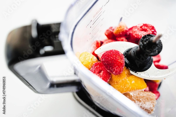 Fototapeta Frozen Fruit Smoothie Prep in Blender Top View with strawberries mango banana