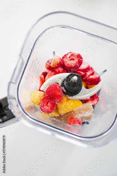 Fototapeta Frozen Fruit Smoothie Prep in Blender Top View with strawberries mango banana
