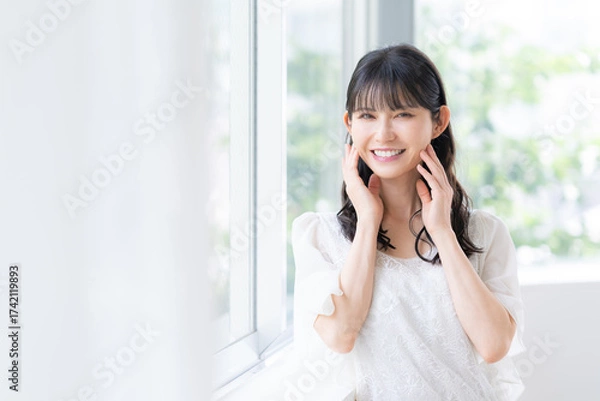 Obraz リビングでスキンケアをするミドルの女性