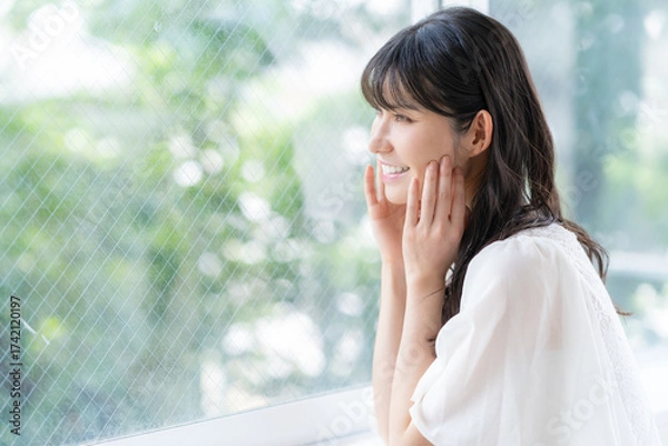 Obraz リビングでスキンケアをするミドルの女性