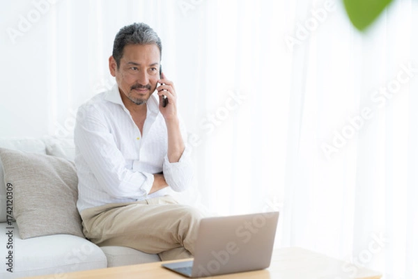 Obraz リビングでテレワークをするミドルの男性