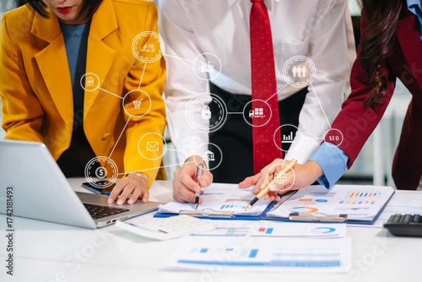Fototapeta Asian business team working on digital marketing strategy, data analytics, SEO, and e-commerce reports in modern office