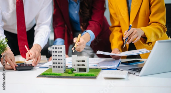 Fototapeta Professionals for a greener future. Showcasing renewable energy solutions with solar panels, wind turbines, and a model house.