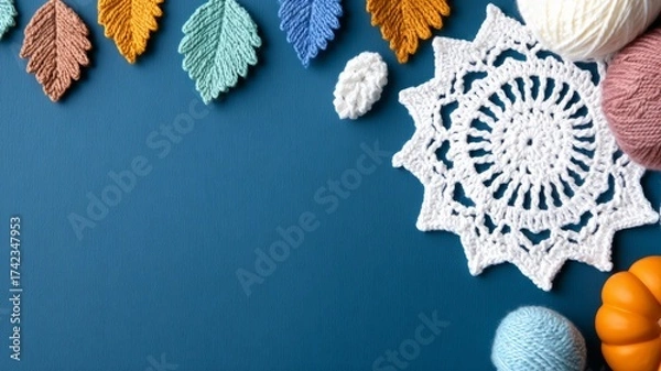 Fototapeta Autumn craft flat lay with crochet doily, colorful yarn balls and knitted leaves on blue background, top view with copy space