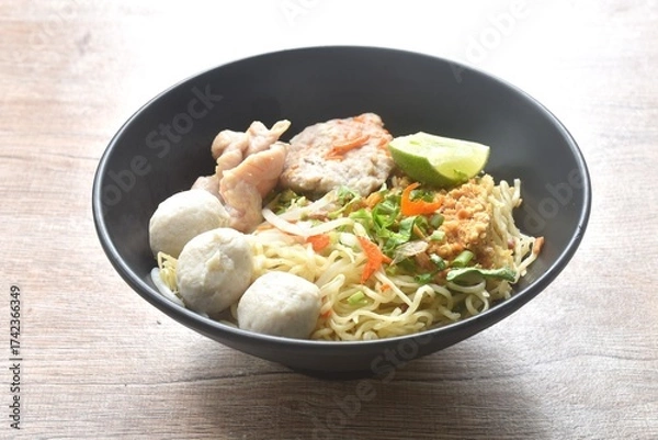 Obraz dry Chinese egg yellow noodles topping boiled chop pork with pork ball dressing cayenne pepper couple shrimp on bowl