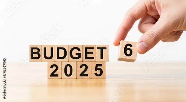 Fototapeta Budget 2025 concept with wooden blocks and hand placing number six on table