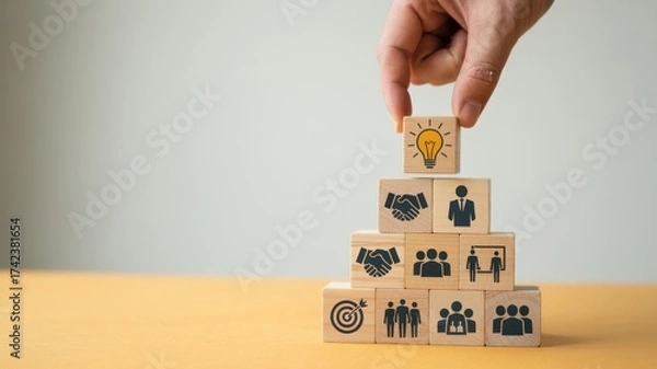 Fototapeta Hand putting wooden block on the stack of wooden blocks with light bulb icon, business strategy and creative idea concept