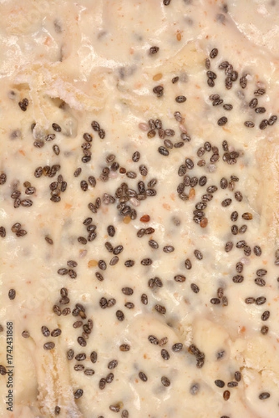 Fototapeta A macro close-up captures the raw bread dough surface generously dotted and covered with dark chia seeds