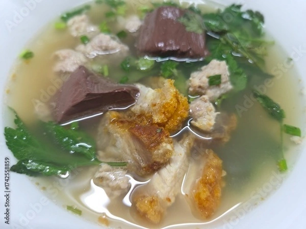 Fototapeta Close-up of Tom Lued Moo, a traditional Thai-Chinese pork blood and offal soup with crispy pork, enjoyed as a popular local specialty.