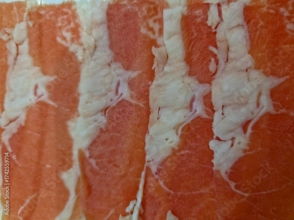 Fototapeta Close up of several very thinly sliced pieces of raw beef chuck