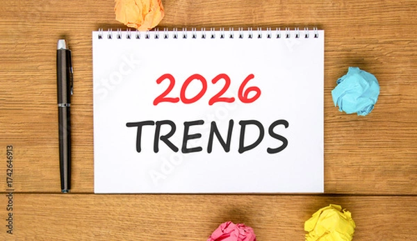 Fototapeta 2026 Trends new year symbol. Concept words 2026 Trends on beautiful white note. Beautiful wooden background. Black pen. Colored paper. Business and 2026 Trends new year concept. Copy space.