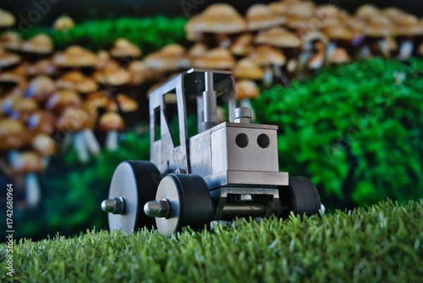 Fototapeta A whimsical macro scene where a toy tractor meets a mushroom forest—blending childhood, fantasy, and industry in a playful visual metaphor. Ideal for themes of creativity, storytelling, and innovation