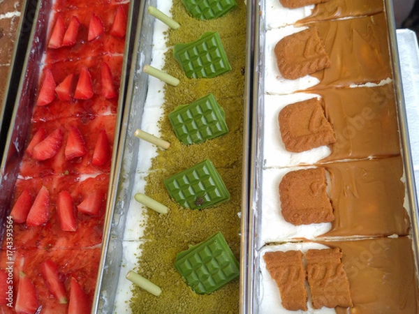 Obraz Assorted cheesecake desserts with strawberry, matcha, and Biscoff toppings