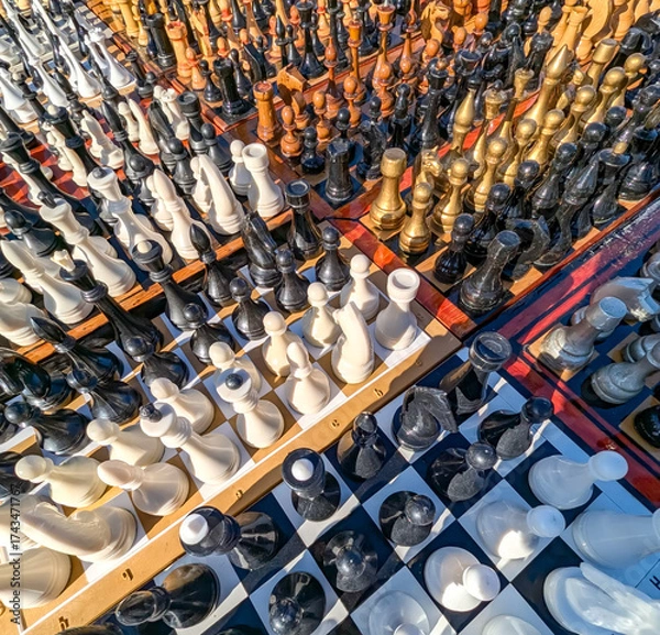 Fototapeta A multitude of wooden chess sets, displayed side by side like a majestic army. A phalanx ready to march into terrifying battle. Wide-angle perspective shot of strategic games intellectual challenges.