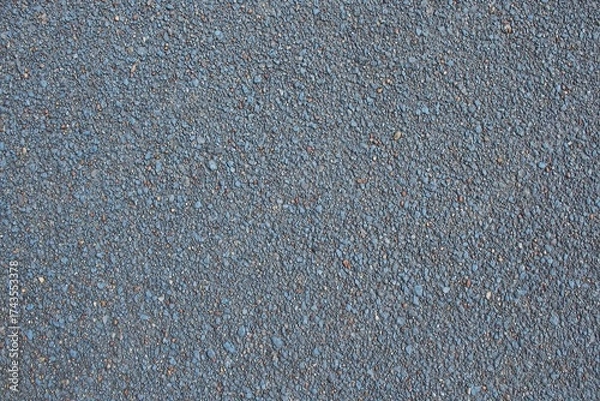 Fototapeta Rough, speckled asphalt surface with tiny pebbles and subtle blue tint