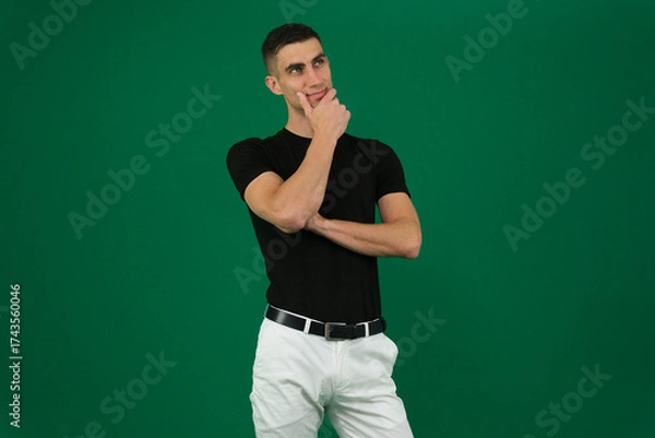 Fototapeta Collection of videos with fit European man in black t shirt and white pants on green chroma key background expressing various emotions smiling thinking surprised serious and confident poses.