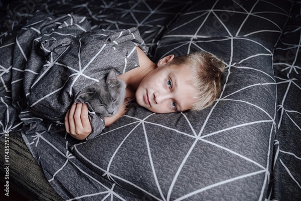 Obraz A handsome blond boy is lying in bed