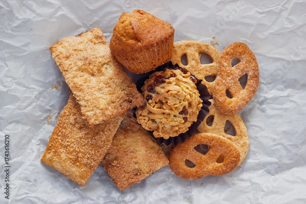 Fototapeta Various cookies for lunch. The heap of  sweets on crumpled paper background, view from above.