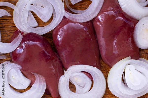 Fototapeta Slicing fresh onions and preparing chicken livers in a cozy kitchen on a sunny afternoon