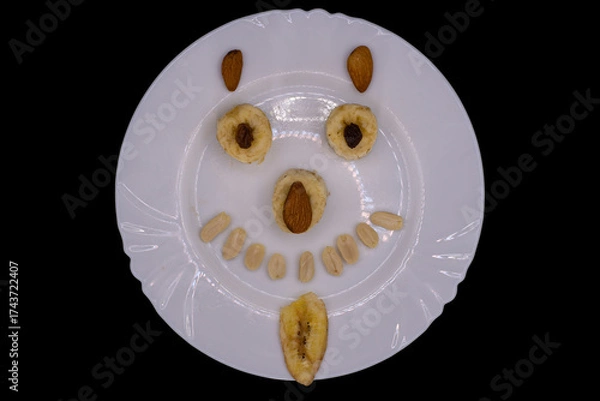 Fototapeta Creative fruit arrangement creates a joyful face on a white plate against a dark background