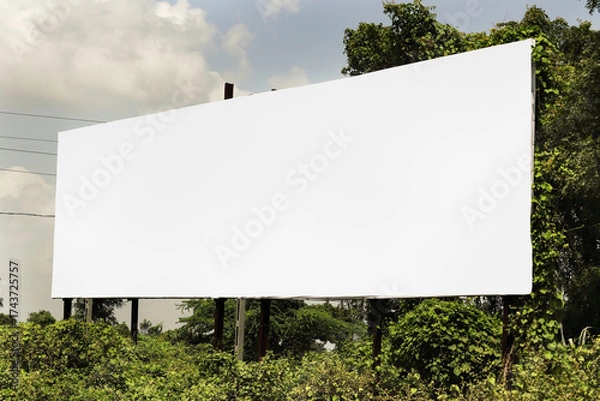 Fototapeta big Billboard on rural area of India, outdoor advertising, mockup billing board in front of green tree and Blank white background for branding design large hoarding. Outdoor advertising construction.