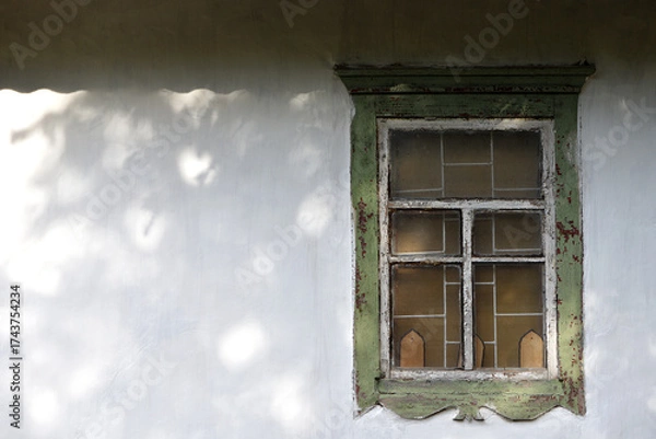 Fototapeta glass Window with old wooden frame. abandoned building. old window. finely broken glass. old house, retro. cracked window frame. cracked old paint, pieces of glass. white wall, space for text