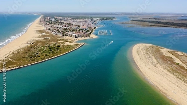 Fototapeta Aerial view over the village, marinas and fishing port of Punta Umbría, and the river Piedras, in the Atlantic coast of Huelva, Andalusia, Spain.
