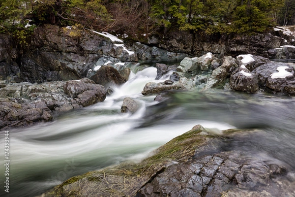 Fototapeta Nature view on the river flowing in between the rocks during winter. Picture taken near Tofino, Vancouver Island, British Columbia, Canada.