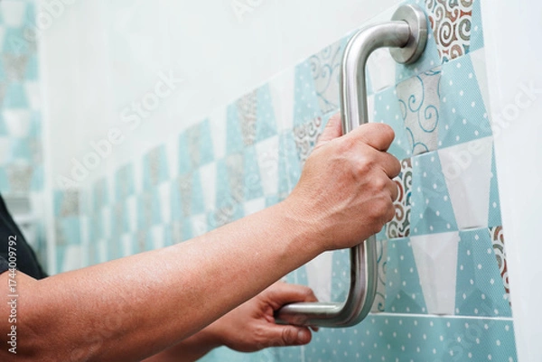 Fototapeta Asian woman patient use toilet support rail in bathroom, handrail safety grab bar, security in nursing hospital.